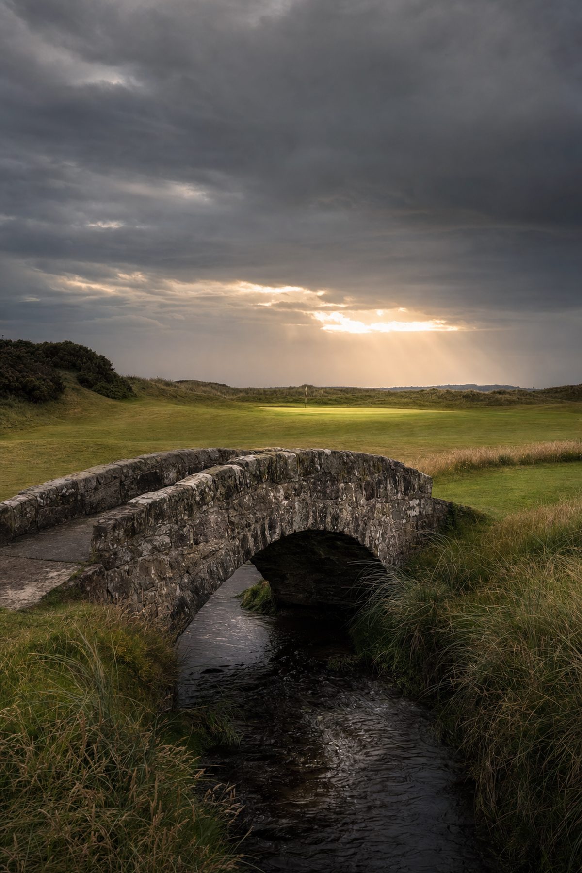 Ancient stone bridge crossing a burn on a wild links golf course